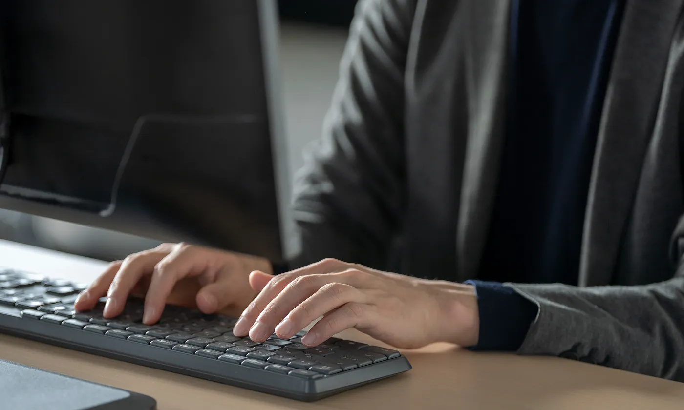 デスクでキーボードを操作し、業務に集中するビジネスパーソンの手元