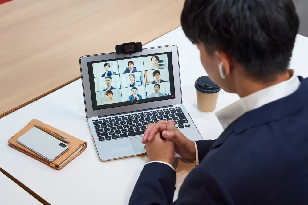 会議室で講師がスライドを使って説明し、複数の参加者がそれを聴講している場面