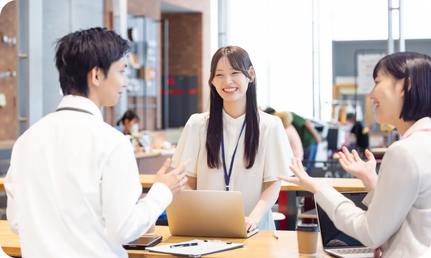 職場で談笑しながら仕事をしている